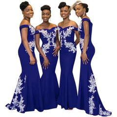 Four women stand side-by-side wearing matching royal blue off-the-shoulder mermaid gowns.