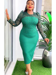 A woman wears a green midi dress with sheer lace sleeves and beaded embellishments on the bodice.