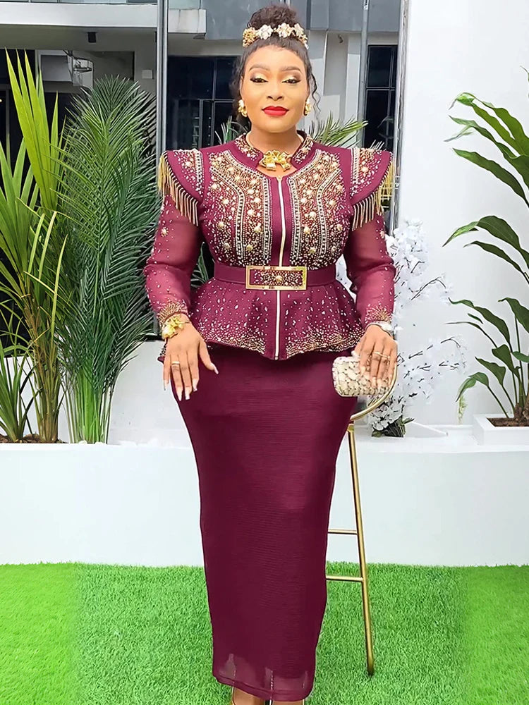 A woman wears a burgundy two-piece set featuring a beaded peplum top and a matching long skirt.