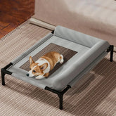 A corgi rests on a grey elevated dog bed featuring a breathable mesh center and a padded pillow.