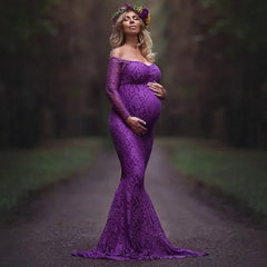 A pregnant woman wears a long-sleeved, purple lace mermaid maternity gown for a photoshoot.