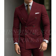 A man wears a slim-fit, double-breasted burgundy suit with a light shirt and textured tie.