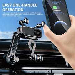 A black gravity car phone holder mounted on an air vent with a smartphone being placed into it.