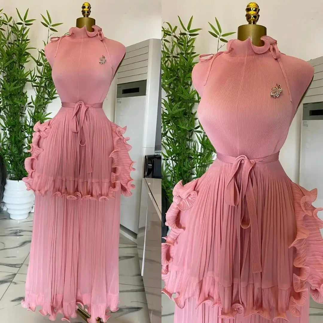 A sleeveless pink pleated midi dress with a ruffled peplum waist and a matching tie belt.