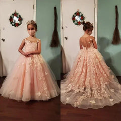 A young girl wears a floor-length pink tulle ball gown with 3D floral and butterfly appliques.