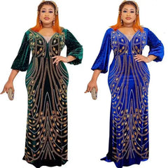 Two women wearing long-sleeved velvet evening dresses with diamond embellishments in green and blue.