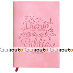 A pink Bible study journal with embossed Spanish text on the cover and a red ribbon bookmark.