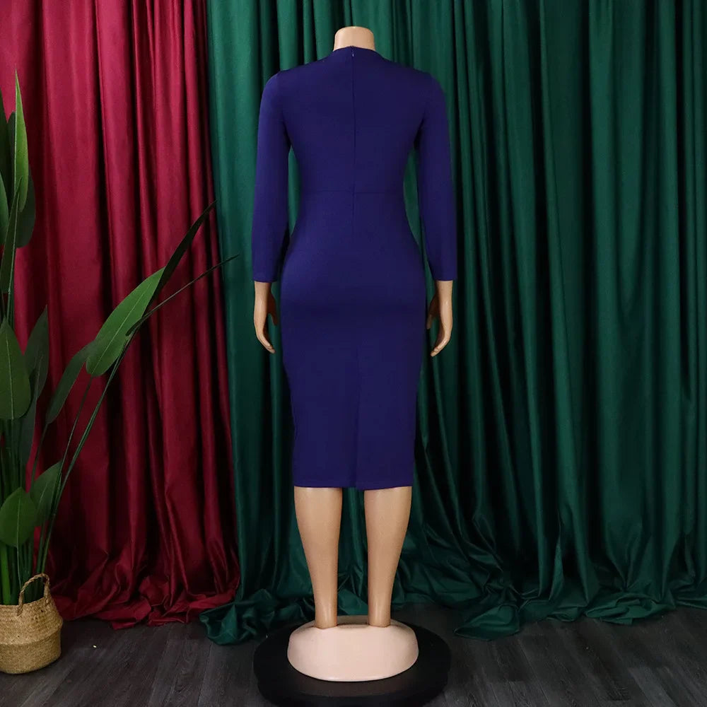 A back view of a solid purple long-sleeved sheath dress with a mid-calf length.