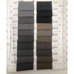 A fabric swatch book displaying various shades of grey and brown suit materials.