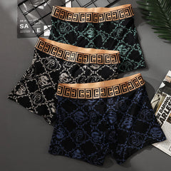 Three pairs of men's boxer shorts with a patterned print and a wide gold elastic waistband.