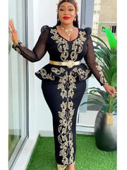 A woman wears a black long-sleeved dress with gold embroidery, a peplum waist, and a gold belt.