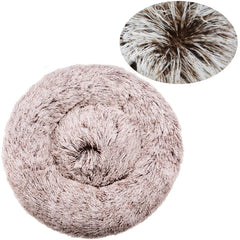 A round, plush pet bed in a soft, light brown color with a textured, shaggy surface.