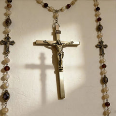 A metal wall crucifix featuring a detailed figure of Jesus Christ with an INRI plaque.