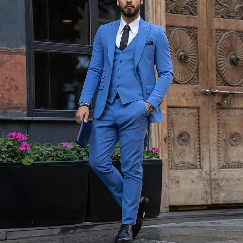 A man wears a bright blue three-piece suit consisting of a jacket, vest, and slim-fit trousers.