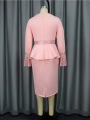 A pink midi dress with a peplum waist, long sleeves with sequined cuffs, and a back zipper.