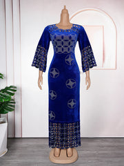 A royal blue velvet maxi dress featuring rhinestone patterns, cut-out details, and flared sleeves.