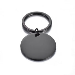 A black circular metal keychain blank attached to a matching split ring on a white background.