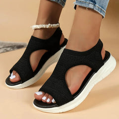 A pair of black mesh open-toe sandals with a white flat platform sole.