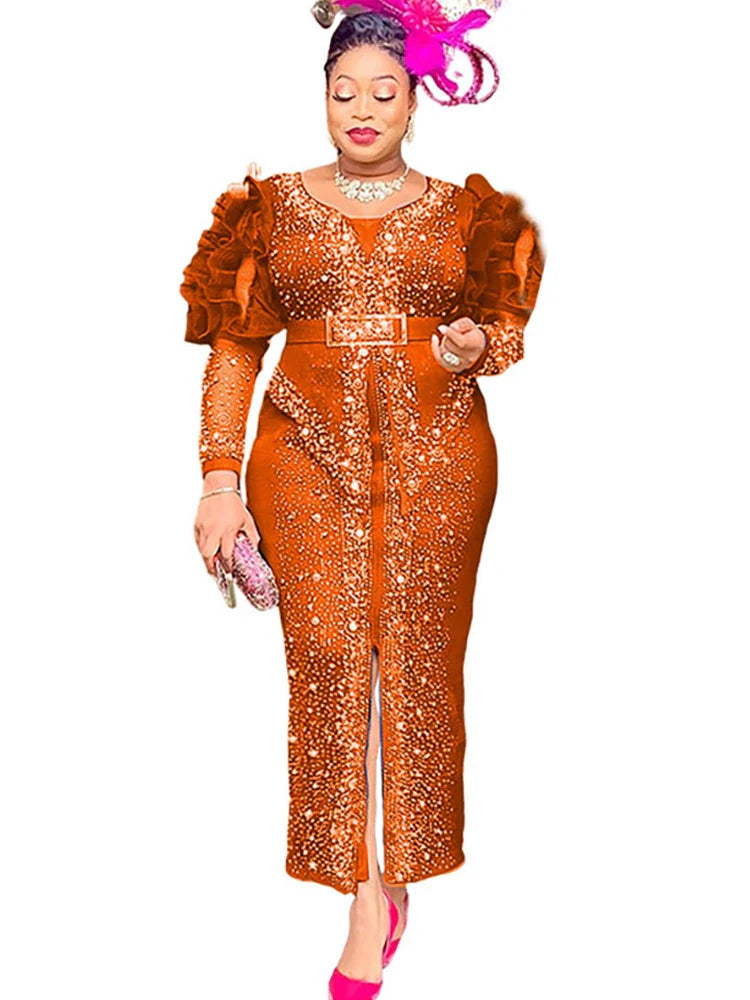 A woman wears a long-sleeved, orange, ankle-length sheath dress decorated with rhinestones.