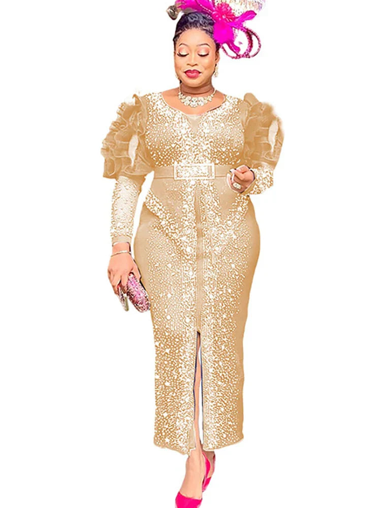 A woman wears a gold, ankle-length sheath dress with puff sleeves, diamond embellishments, and a belt.