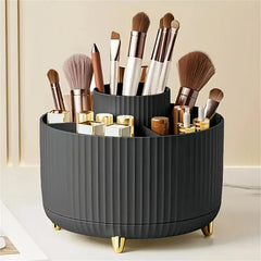 A dark gray, ribbed, rotating makeup organizer with five compartments and gold-toned feet.