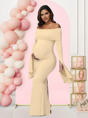 A pregnant woman wears a solid beige off-shoulder long-sleeve mermaid maternity dress.