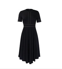 A black short-sleeved A-line dress with white contrast stitching and a pleated high-low skirt.