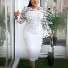A woman wears a white midi-length sheath dress with long patterned sleeves and beaded detailing.