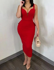 A woman wears a red, sleeveless, mid-calf sheath dress with a deep plunge neckline.