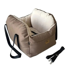 A tan and cream pet car booster seat with a safety strap and a detachable shoulder strap.