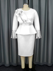 A white knee-length sheath dress with a ruffled shoulder, sequined waist, and flared cuffs.