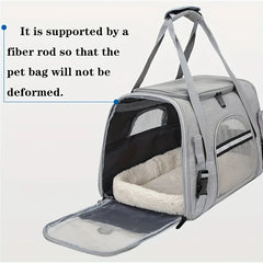 A grey soft-sided pet carrier with mesh windows and a plush interior pad.