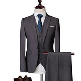 A charcoal grey three-piece men's suit featuring a blazer, vest, and matching trousers.