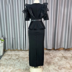 A black, short-sleeved, floor-length bodycon dress with ruffled shoulders and a peplum waist.