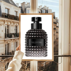 A framed poster featuring a Valentino perfume bottle with a textured glass design.