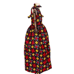 A girl's sleeveless African print maxi dress in red, black, and yellow with a matching headscarf.