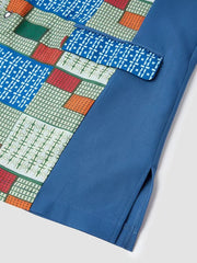 A close-up of a blue men's kaftan featuring a colorful geometric patchwork pattern.