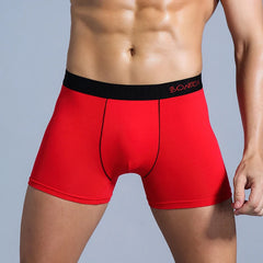 A man wearing red cotton boxer shorts with a black waistband featuring the Bonitos logo.