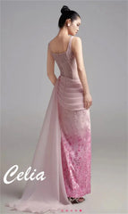 A model wears a floor-length pink evening gown with a pleated waist and floral embroidery.