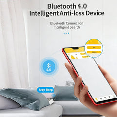 A hand holds a smartphone displaying a tracking app interface next to a small Bluetooth anti-loss device.