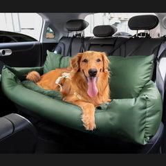 A golden retriever rests inside a green, cushioned dog car seat on the back seat of a vehicle.