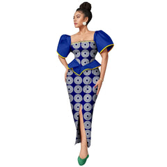 A woman wears a blue and white patterned ankle-length dress with puff sleeves and a front slit.