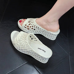 A pair of white wedge slippers featuring a hollow-out rope design and a thick platform sole.