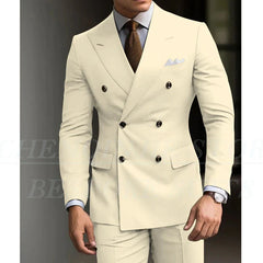 A man wears a cream-colored double-breasted slim-fit suit with a brown tie and pocket square.
