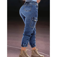 A person wearing blue denim cargo jeans with elastic cuffs and side pockets.