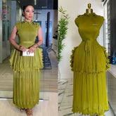 A sleeveless olive green pleated midi dress with a ruffled peplum waist and a matching belt.