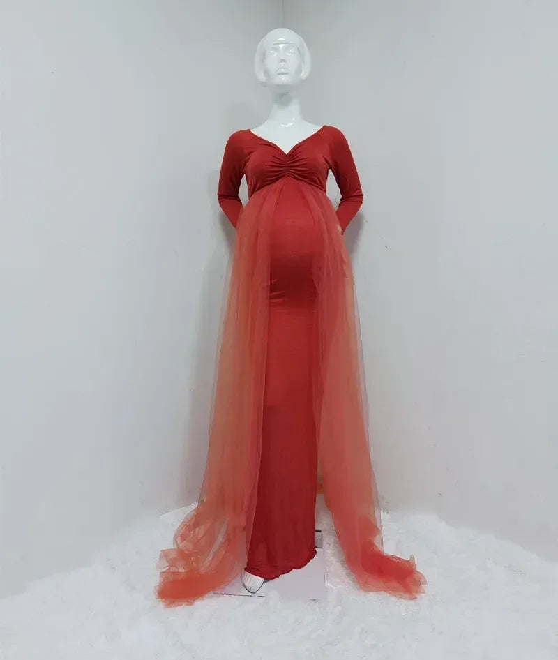A red long-sleeved maternity dress with a V-neck and a sheer tulle cape train.