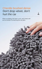 A hand touches a dense gray chenille car wash mitt with soft, textured fabric strands.