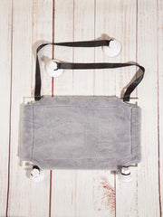 A grey plush cat hammock with a white frame and four suction cups for window mounting.
