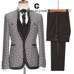A three-piece men's suit featuring a black and white geometric patterned blazer, vest, and pants.